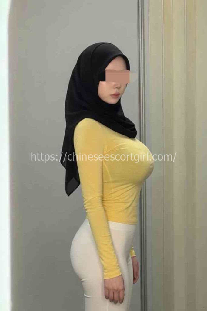 Zana, a 22yo Malay escort in KL, wearing a yellow top and white pants.