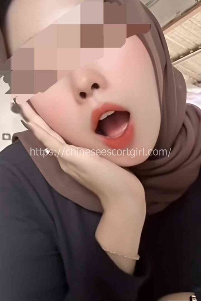 Young Malay woman in hijab with open mouth, close-up