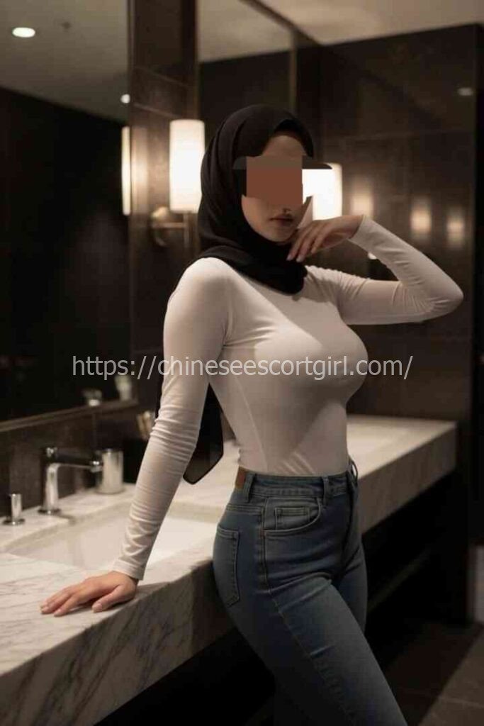 Zana, a 22yo Malay escort in KL, wearing a white top and jeans.